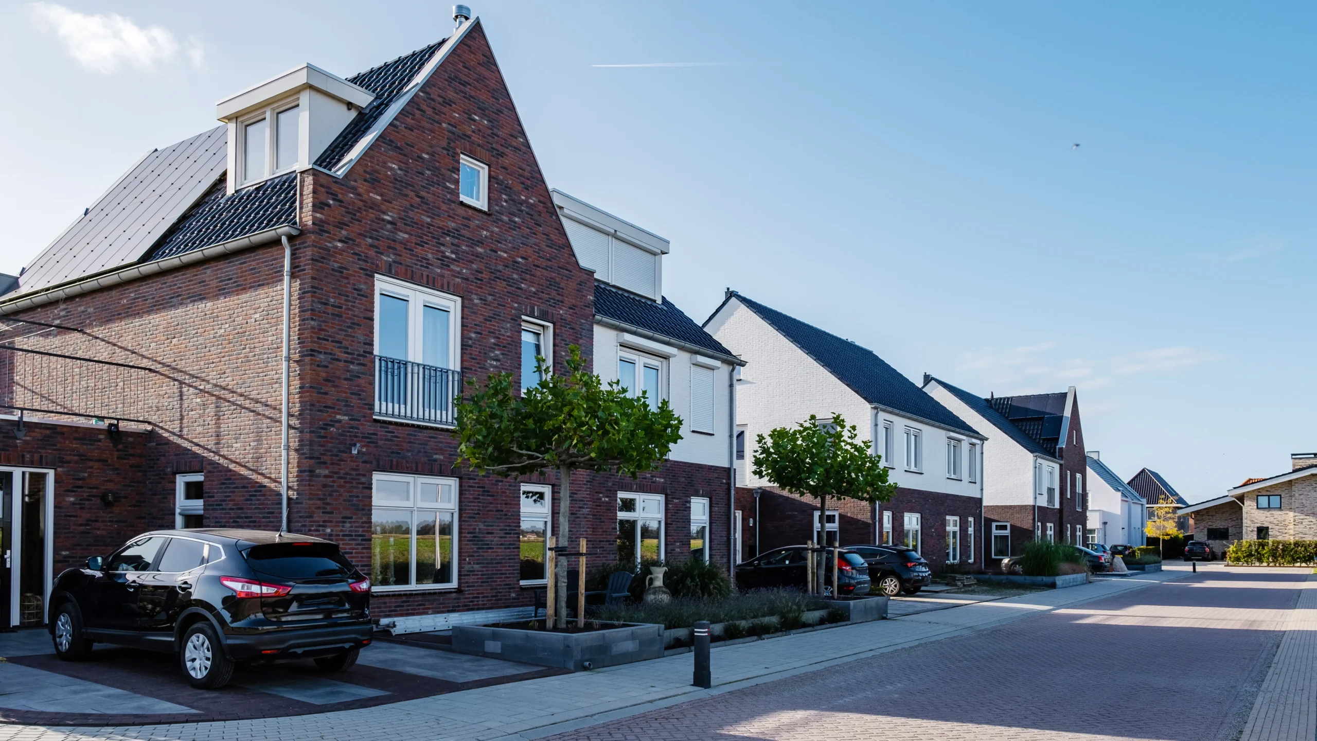 A row of houses on a new build estate with a mixture of brick and rendered properties.